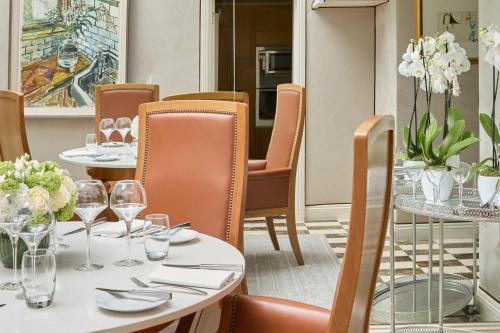 a restaurant with tables and chairs with wine glasses at The Montague On The Gardens in London