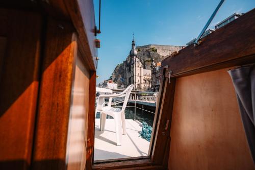 a window on a boat with a view of a city at Pénichettes Dinant Evasion in Dinant