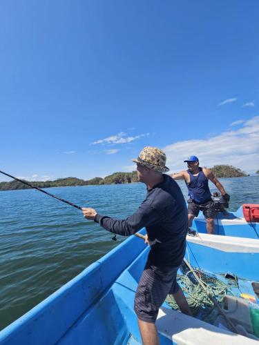 a man holding a fishing pole in a boat at Beach resort playa Leona in Gigantes