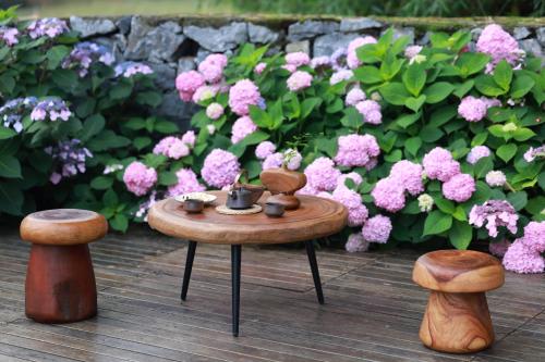 a table with a tea set on it in front of pink flowers at The Apsara Lodge-Airport or TS Free pick-up over 3 nights in Yangshuo