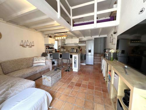 Il comprend un grand salon avec un canapé et une cuisine. dans l'établissement Le Costabella - Appartement pour 4 personnes à 5 minutes de la plage de l'Almanarre à Hyères, à Hyères