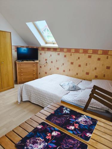 a bedroom with a bed and a television and a window at Pokoje gościnne nad Zalewem in Dziwnówek