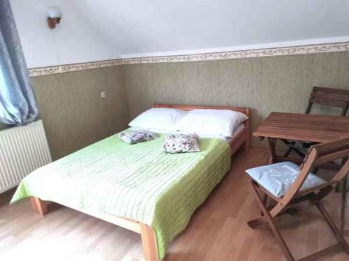a bedroom with a bed and a table and a chair at Pokoje gościnne nad Zalewem in Dziwnówek