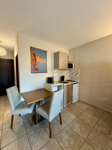une cuisine avec une table et des chaises dans une pièce dans l'établissement Grand Studio dans Residence avec piscine in Sisco, à Sisco