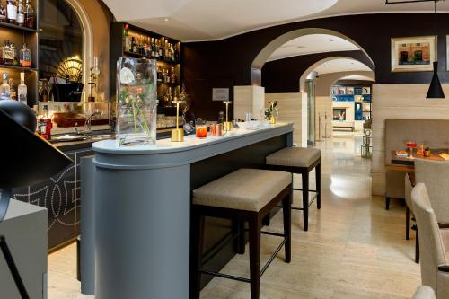 a bar in a restaurant with stools at a counter at Hotel Indigo Rome - St. George by IHG in Rome
