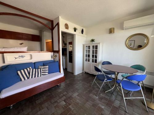 - une chambre avec des lits superposés, une table et des chaises dans l'établissement HYECAU Studio pour 4 personnes avec vue mer sur le port d'Hyères, à Hyères