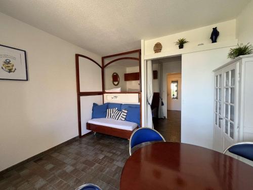 une chambre avec un lit, une table et des chaises dans l'établissement HYECAU Studio pour 4 personnes avec vue mer sur le port d'Hyères, à Hyères