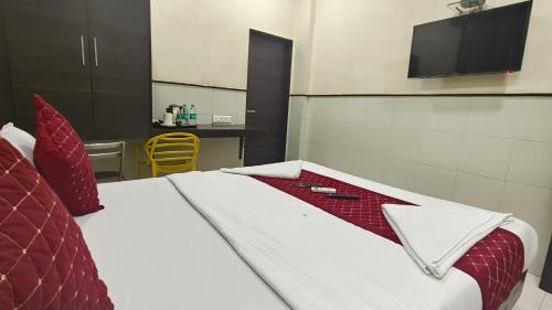 a hotel room with a bed with red pillows at Smooth Checkin by Sion TriTon - Mumbai in Mumbai