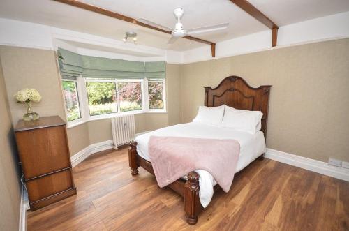 una camera con un grande letto e due finestre di The Sheriff House - Beautiful large property in Wroxham, perfect for family holidays a Wroxham