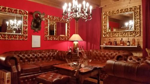 a living room with brown leather couches and mirrors at Ferienhaus Alpenpanorama Chalet in Mollenberg