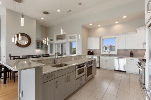a large kitchen with white cabinets and a counter top at 3025 - Who's On First in Southern Shores