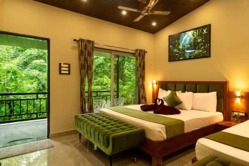 a bedroom with a bed and a large window at Dream Valley resort in Dandeli