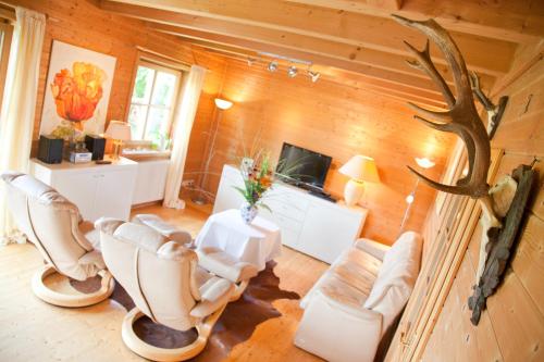 a living room with white chairs and a table at Ferienhaus Alpenpanorama Chalet in Mollenberg