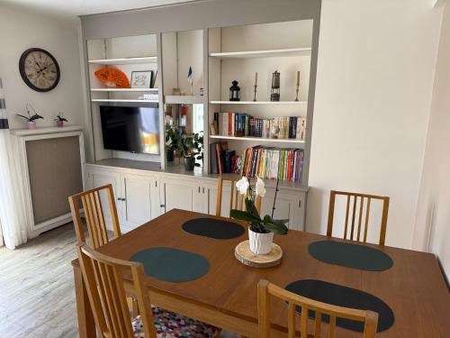 une table à manger avec des chaises et une télévision dans l'établissement Appartement vue sur collines de Cannes, au Cannet
