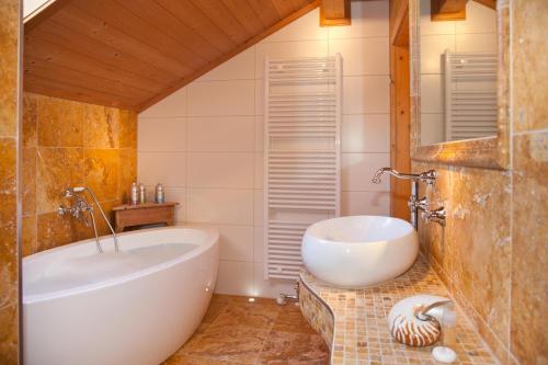a bathroom with a tub and a sink at Ferienhaus Alpenpanorama Chalet in Mollenberg
