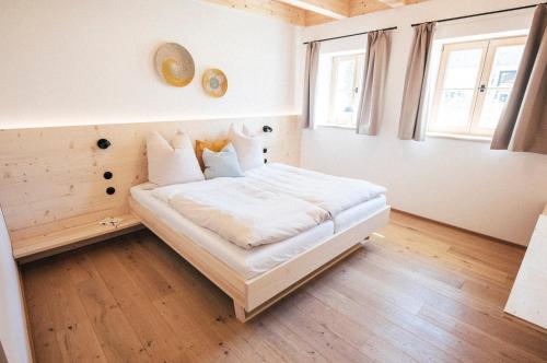 a bedroom with a bed with white sheets and pillows at Das Frialing in Altenmarkt an der Alz