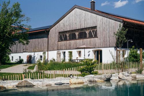 a barn with a pond in front of a building at Das Frialing in Altenmarkt an der Alz