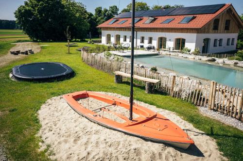 an orange kayak sitting on the sand in front of a house at Das Frialing in Altenmarkt an der Alz