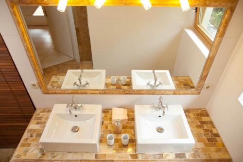 a bathroom with two sinks and a mirror at Ferienhaus Alpenpanorama Chalet in Mollenberg