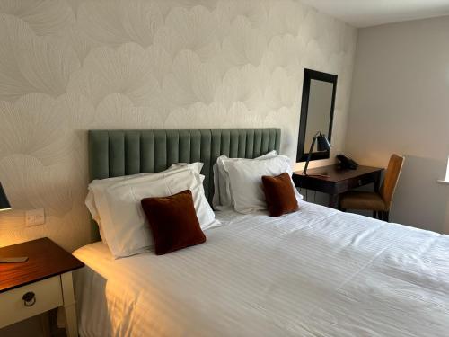 a bedroom with a large bed with a green headboard at Hatherley Manor Hotel & Spa in Gloucester