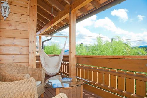 a screened in porch with two chairs and a swing at Ferienhaus Alpenpanorama Chalet in Mollenberg