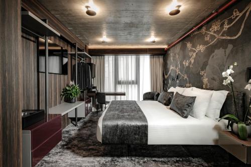 a bedroom with a large white bed and a desk at Fitch Hotel in St Julian's