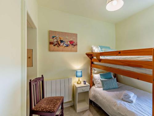 a small bedroom with a bunk bed and a chair at 2 Bed in Grassington 93941 in Hebden