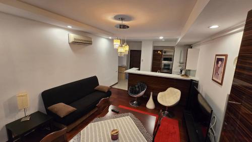 a living room with a couch and a kitchen at AVS Concept Cosmopolis in Ştefăneştii de Sus