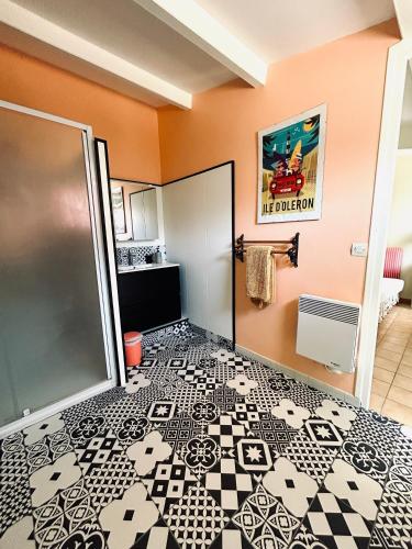 La salle de bains est pourvue de carrelage noir et blanc. dans l'établissement Un air de famille, à Saint-Pierre-dʼOléron