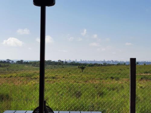 a view of a field from a window with a fence at SASH-Resort in San Juan del Paraná