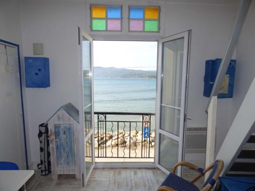 Cette chambre avec porte ouverte offre une vue sur l'océan. dans l'établissement Rare à la location, pieds dans l' eau, pleine vue mer, wifi ..., à La Seyne-sur-Mer