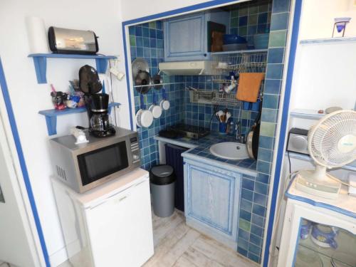 une petite cuisine avec un évier et un micro-ondes dans l'établissement Rare à la location, pieds dans l' eau, pleine vue mer, wifi ..., à La Seyne-sur-Mer