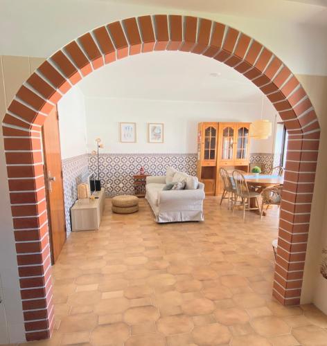 an archway in a living room with a couch and a table at Family Apartment with Balcony, 5 min from the Beach in Santa Cruz