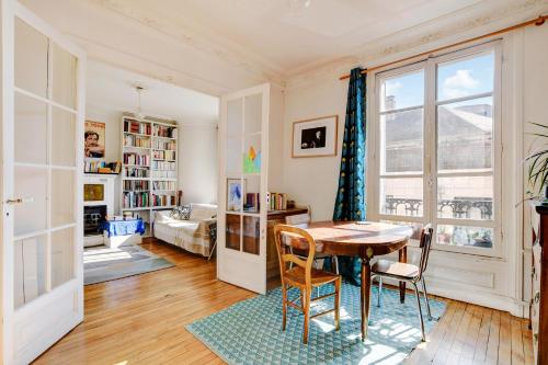une salle à manger avec une table et des chaises et une chambre dans l'établissement Appartement proche bois, à Vincennes