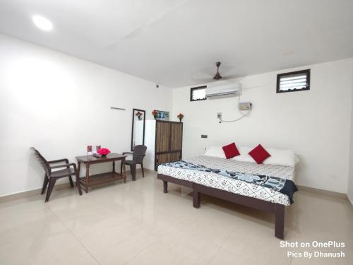 a bedroom with a bed and a table with chairs at Annamaiah Guest House & Homestay - Tirupati - Home Food Service in Tirupati