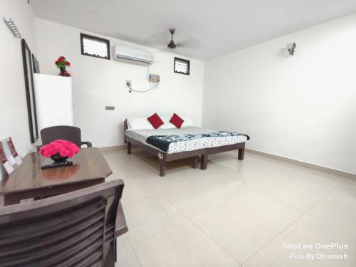 a room with a bed and a table in it at Annamaiah Guest House & Homestay - Tirupati - Home Food Service in Tirupati