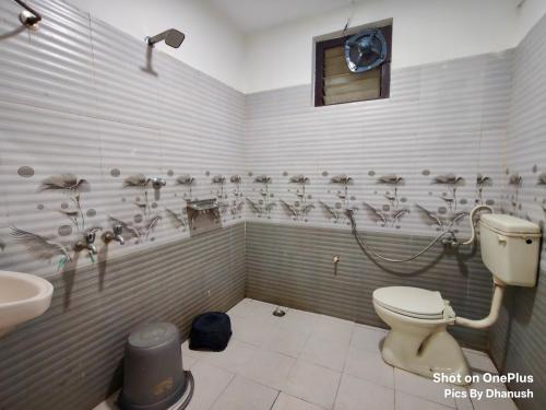 a bathroom with a toilet and a sink at Annamaiah Guest House & Homestay - Tirupati - Home Food Service in Tirupati