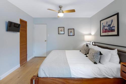a bedroom with a white bed and a ceiling fan at California Dreamin by AvantStay Private Pool Fire Pit Near the Beach in Carlsbad