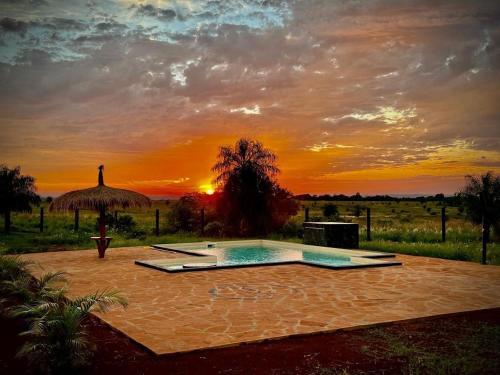 a swimming pool with a sunset in the background at SASH-Resort in San Juan del Paraná