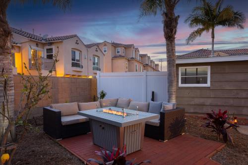 a patio with a table and chairs in a backyard at California Dreamin by AvantStay Private Pool Fire Pit Near the Beach in Carlsbad