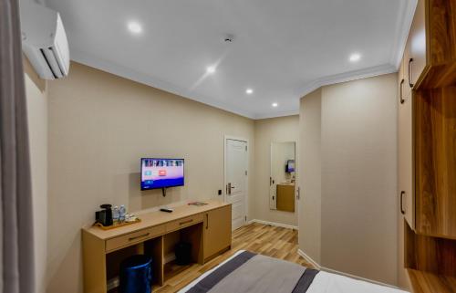 a room with a desk and a tv on the wall at Hillside Boutique Hotel Baku in Baku