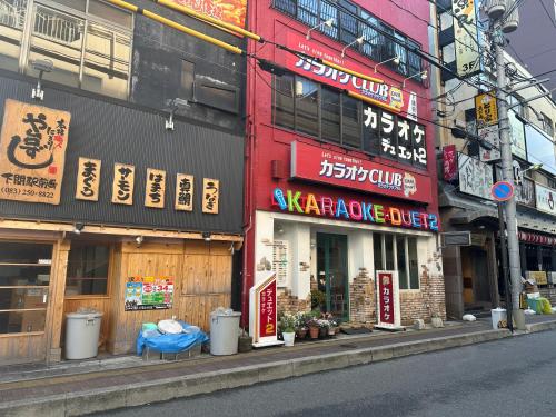 a building with signs on the side of a street at Guest House" Ro" takezaki in Amanogōchō
