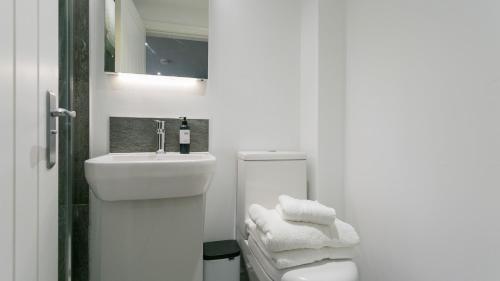 une salle de bain blanche avec un lavabo et des toilettes dans l'établissement 3 Beach Terrace, à Rhosneigr