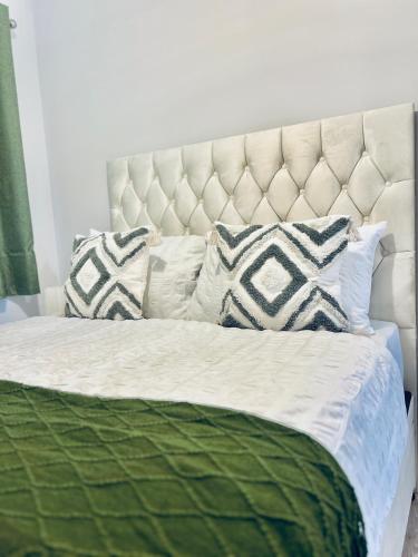 a bedroom with a white bed with pillows at Dover Ferry Apartments, private terrace and on-site parking in Dover