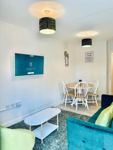 a living room with a table and chairs and a tv at Dover Ferry Apartments, private terrace and on-site parking in Dover