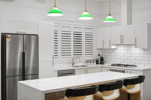 a kitchen with white cabinets and a large white counter top at Picture Perfect Create timeless treasures in Perth