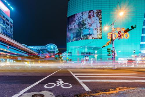 a city street at night with a building and a bike lane at Deja Vu Hotel in Taipei