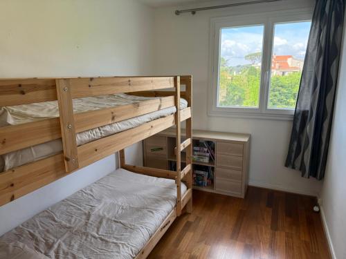 une chambre avec deux lits superposés et une fenêtre dans l'établissement Appartement vue sur collines de Cannes, au Cannet