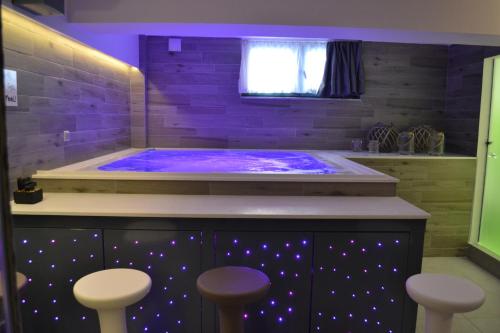 jacuzzi z fioletowym oświetleniem w łazience w obiekcie Eco Paralia w Paralii Katerinis