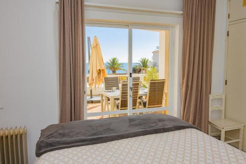 a bedroom with a bed and a view of a patio at Apartamento Casa do Mar Praia da Luz in Luz